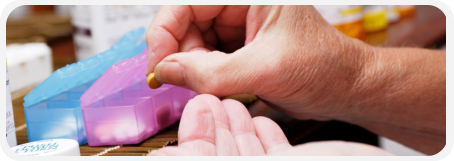 elderly hand holding a medicine tablet